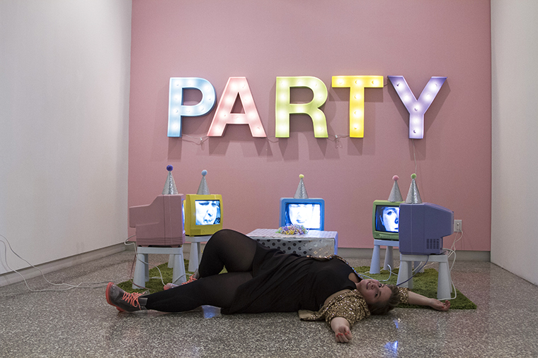 person laying on ground in front of party sign
