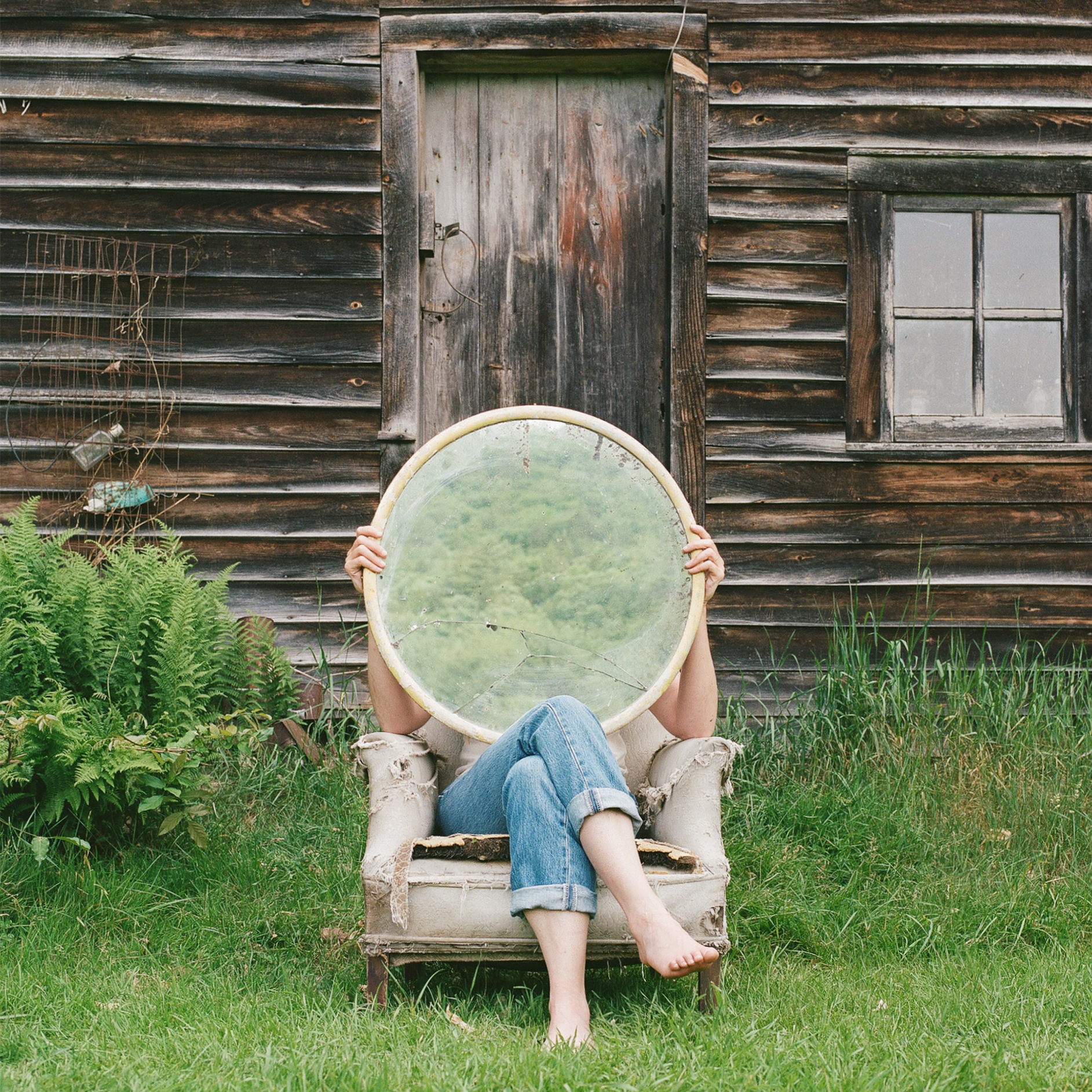 person with round mirror on chair outdoors